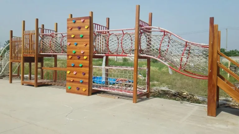 Playground Equipment Manufacturer | Indoor Soft Play & Custom Outdoor Playgrounds | Xinjiu Timber climbing structure with a rope bridge and climbing wall