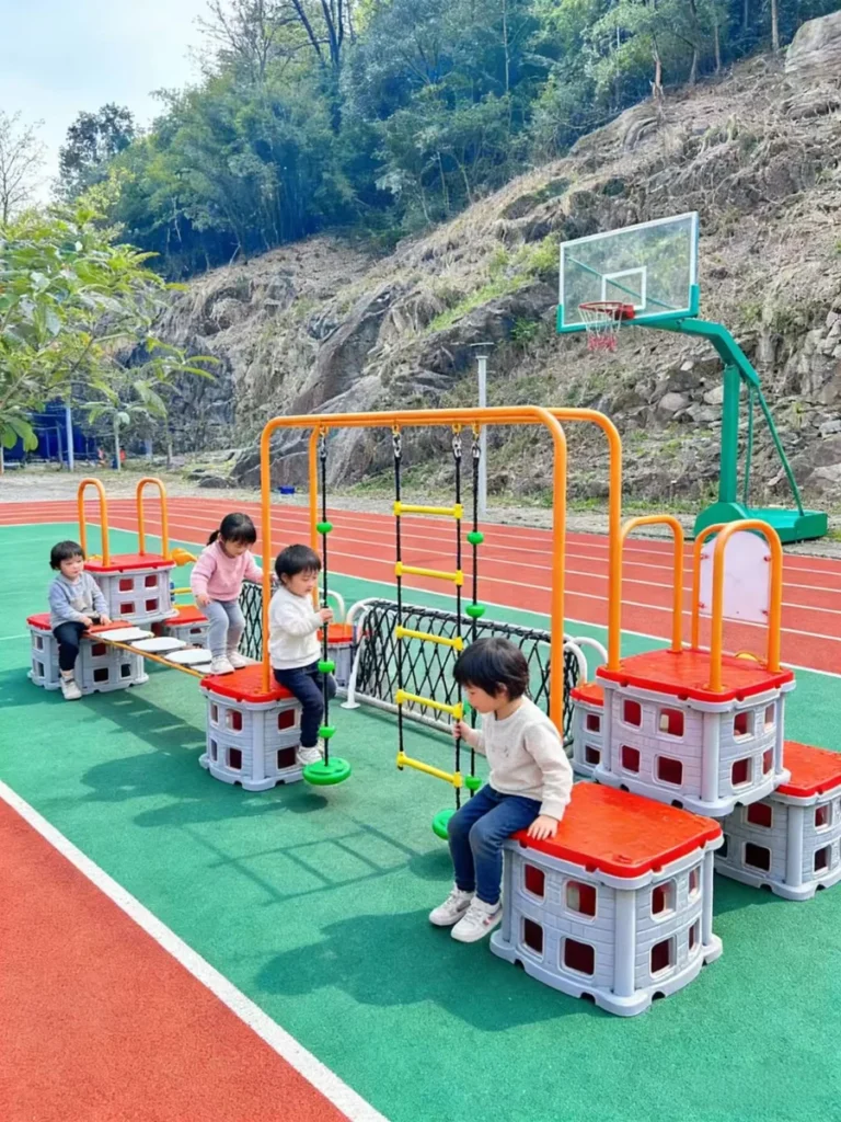 Playground Equipment Manufacturer | Indoor Soft Play & Custom Outdoor Playgrounds | Xinjiu Children exploring modular outdoor activity equipment on a colorful court