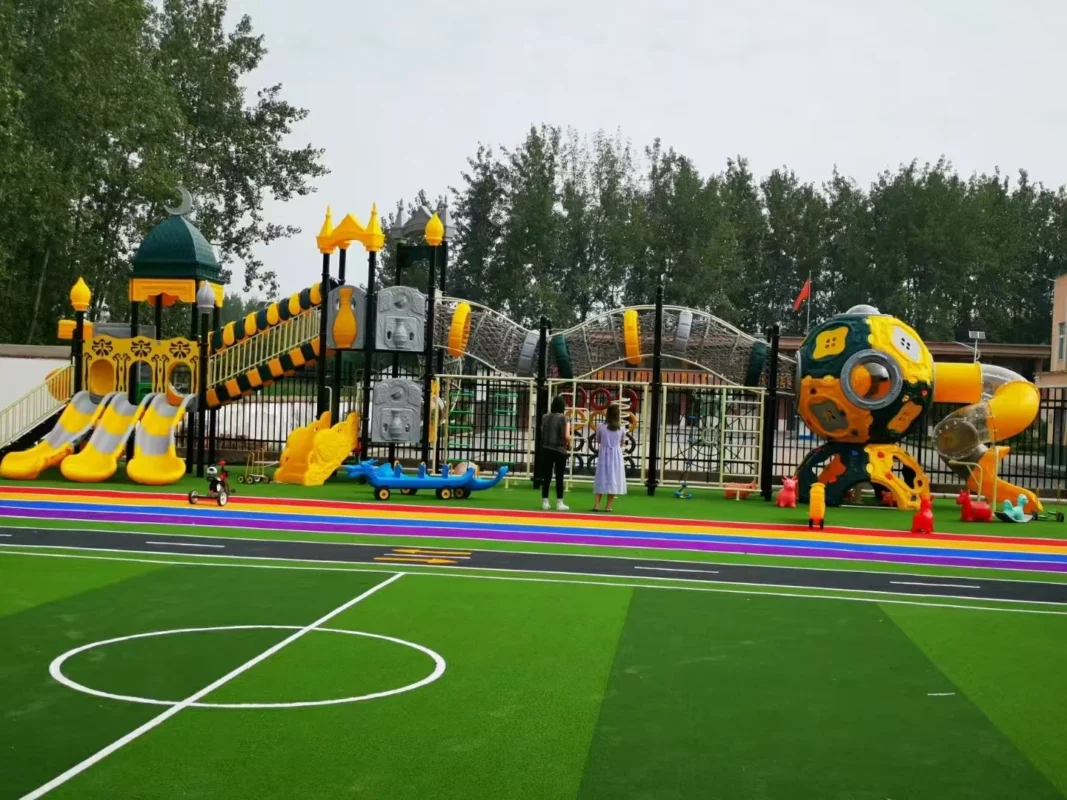 Playground Equipment Manufacturer | Indoor Soft Play & Custom Outdoor Playgrounds | Xinjiu Yellow-themed playground beside a colorful outdoor sports and activity area
